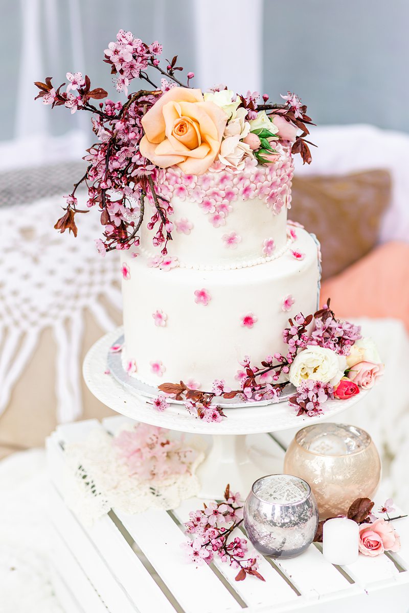 White wedding cake decorated with cherry blossoms and flowers. 