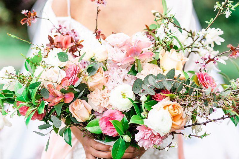 close up image of a bridal bouquet featuring fresh cherry blossoms