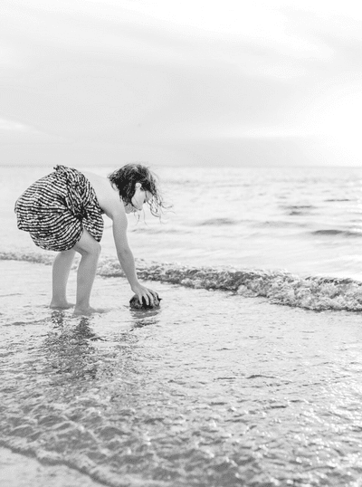 A young girl floating a coconut in the ocean