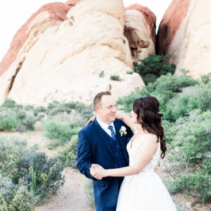 Couple dancing in front of a pink rocky outcrop at their elopement